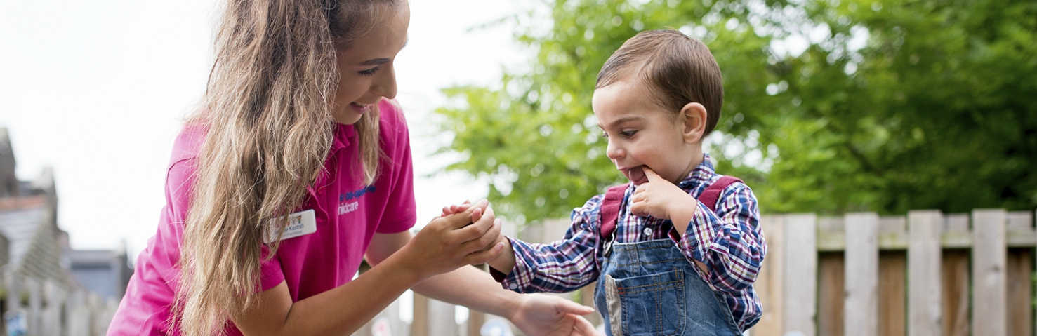 nursery practitioner helps child